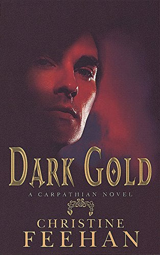 Book cover featuring a man's face in red shadow, titled Dark Gold by Christine Feehan.