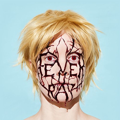 Close-up of a person with cracked face paint and red eyes.
