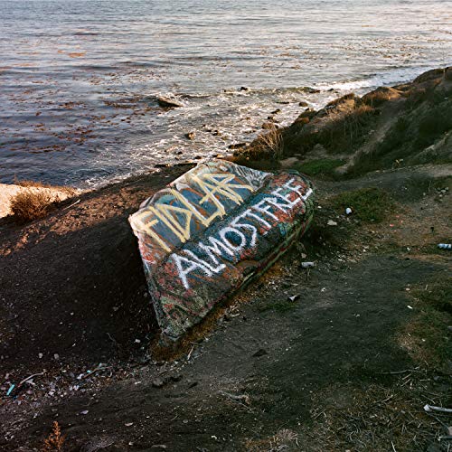 Album cover for Fidlar’s “Almost Free” featuring graffiti on a rock by the sea.