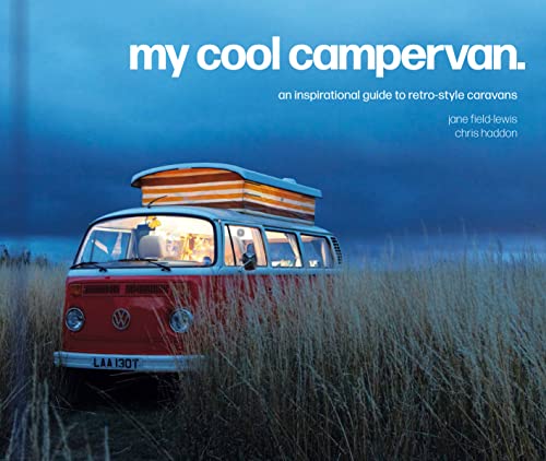A red and white Volkswagen campervan parked in a grassy field at twilight.