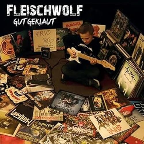 Boy with guitar surrounded by vinyl records and album artwork.