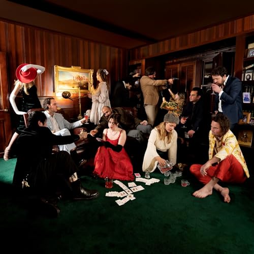 Group of people in formalwear gathered in a dimly lit, ornate room.