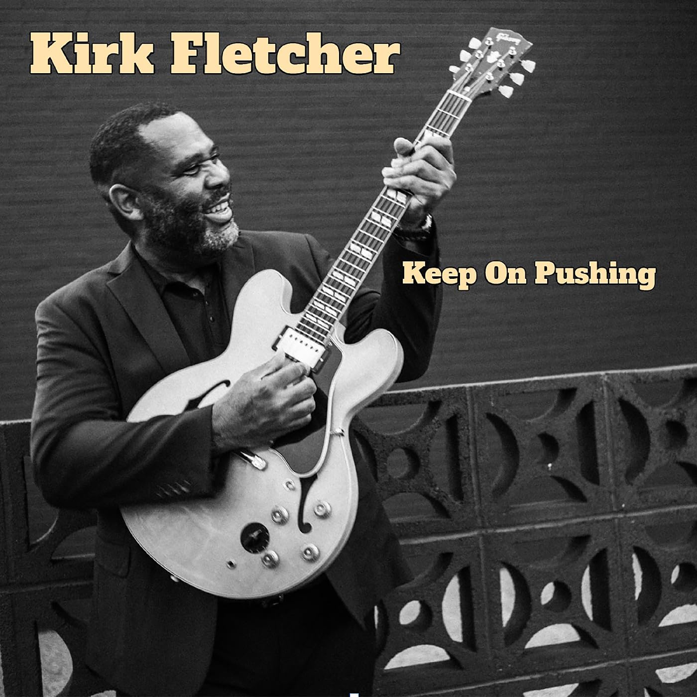 Kirk Fletcher smiling, holding a Gibson guitar, album cover art.
