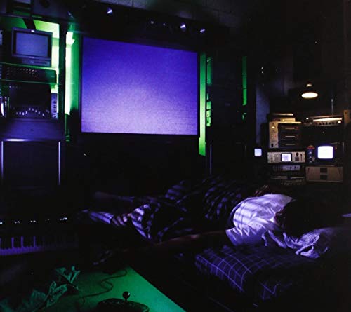 Dark room with vintage electronics, a large screen, and a reclining figure.