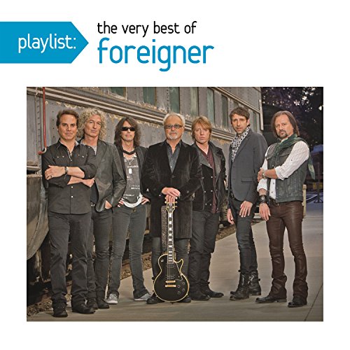 Foreigner band members posing in front of a blurred train car.