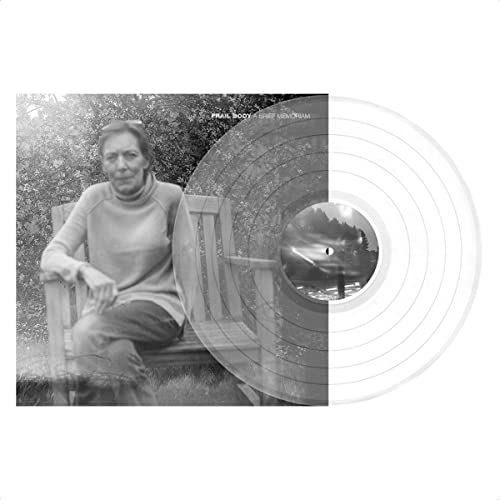Black and white photo of a woman on a bench beside a clear vinyl record.