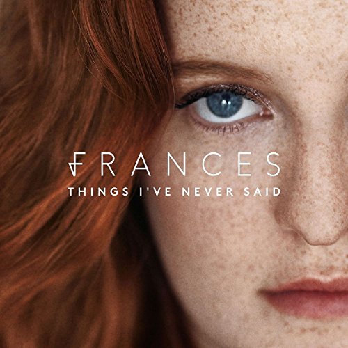 Close-up of a woman with red hair and freckles, album cover.