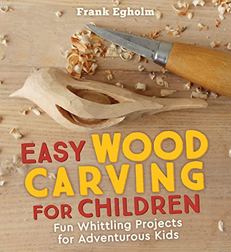 A carved wooden bird and a whittling knife on a wood surface with shavings.