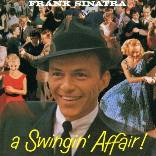 Frank Sinatra wearing a fedora in front of a crowded ballroom dance scene.
