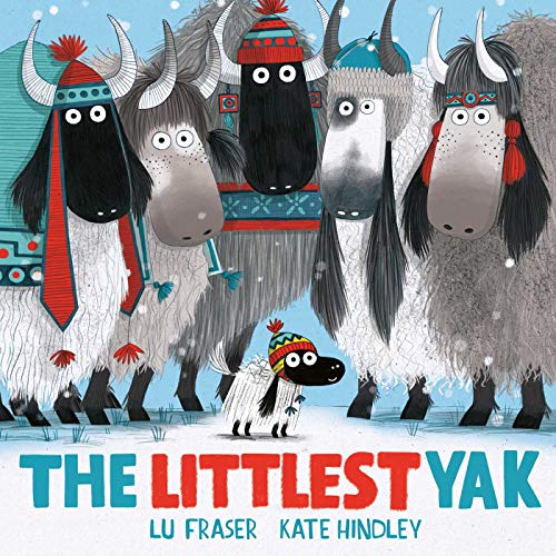 A small yak wearing a colorful hat stands before several larger yaks in snow.