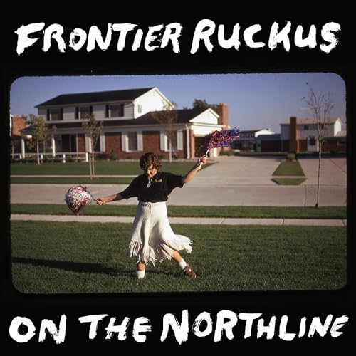 CD cover: woman in a skirt and t-shirt with pom-poms on a lawn.