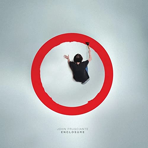 A person in a black shirt paints a red circle on a gray background.