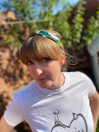 Woman with short brown hair wearing a patterned headband outdoors.
