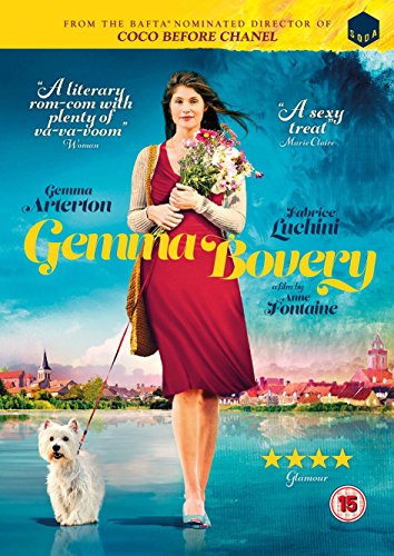 A woman in a red dress holds flowers and walks a white dog outdoors.