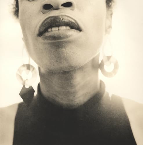 Close-up black and white portrait of a person with large hoop earrings.