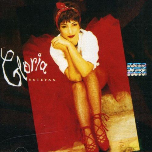Gloria Estefan album cover featuring her in a red dress and lace-up heels.