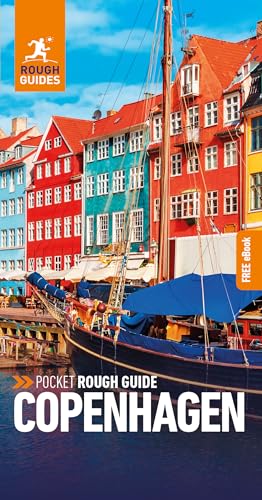 A sailboat docked in front of colorful historic buildings along a canal in Copenhagen.