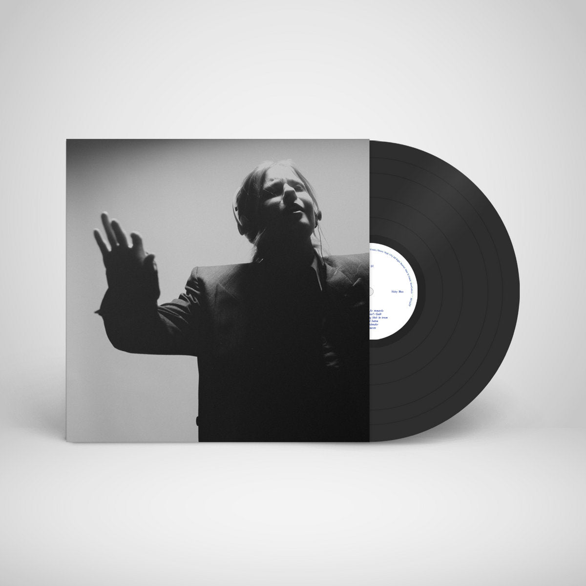 Black vinyl record with black and white album cover featuring a person.