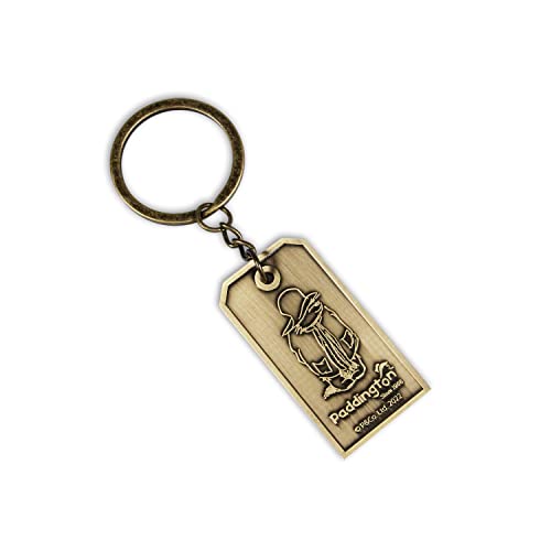 Antique brass-colored metal keychain featuring an engraved Paddington Bear design on a rectangular tag.