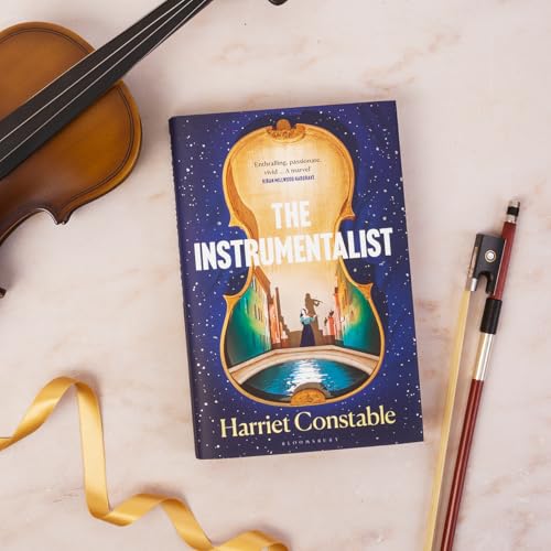 Book cover with a violin illustration, bow, and ribbon on marble.