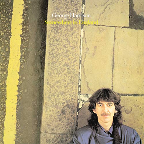 George Harrison album cover showing him against a stone wall with a yellow line.
