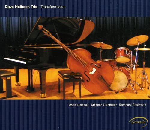Jazz trio with piano, double bass, and drums on a stage.