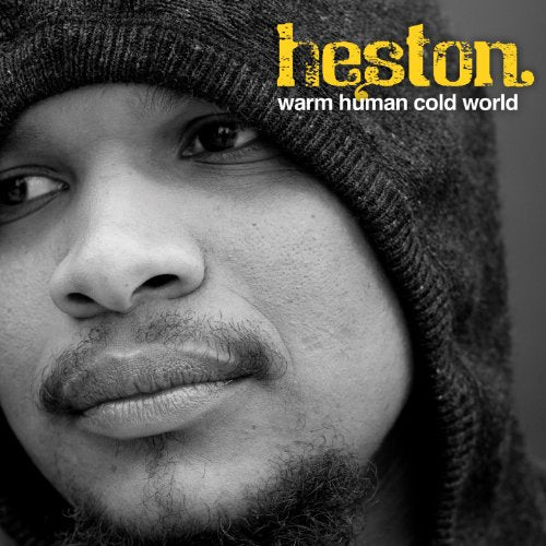 Black and white close-up of a man's face wearing a beanie, with yellow and white text.