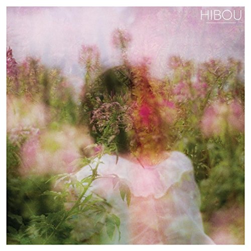 Blurred image of a person in a field of pink and white flowers.