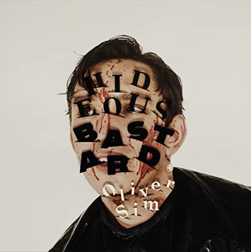 Man’s face obscured by red text, “HIDEOUS BASTARD”, and dripping red marks.