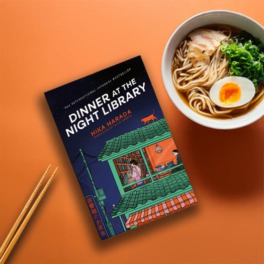 Book titled Dinner at the Night Library next to ramen bowl and chopsticks.