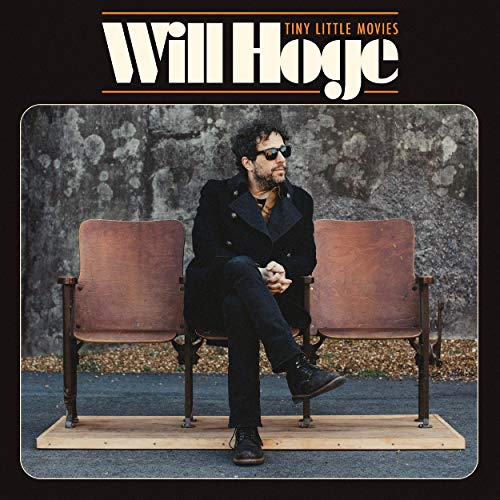 "Album cover featuring a man sitting on a chair, wearing sunglasses and a black jacket."