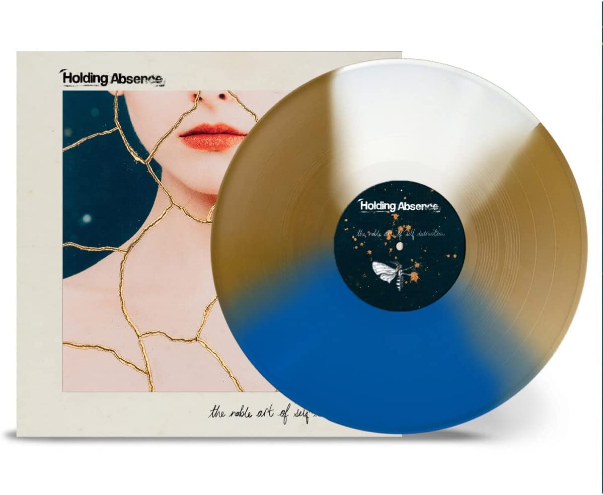 Holding Absence vinyl record with blue and gold split design and album cover art.
