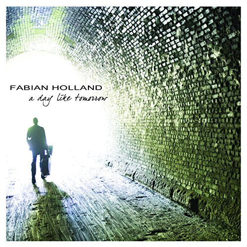 Man walking towards light at the end of a brick tunnel.