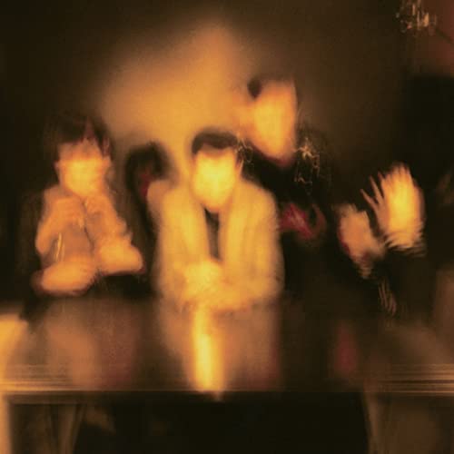 Blurred image of four people in warm, muted tones.