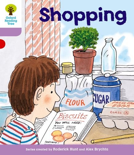 A boy reads a biscuit recipe book surrounded by kitchen ingredients like flour and sugar.