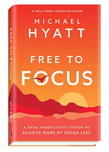 Orange book cover with white text: “Free to Focus” and mountain landscape.