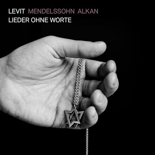 Black and white album cover featuring a hand holding a star pendant.