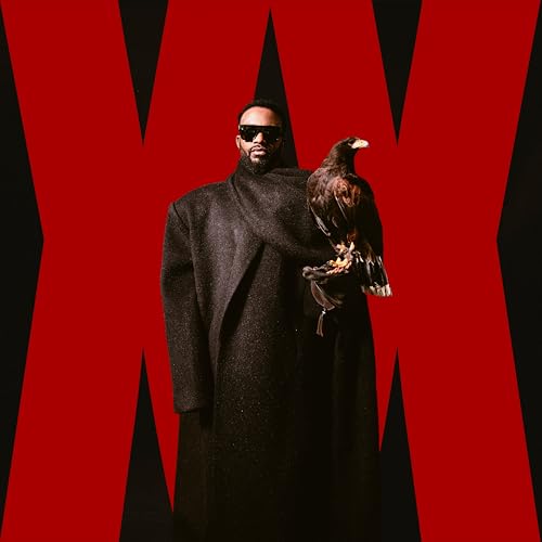 Fally Ipupa in black coat holding a brown eagle against red geometric background.