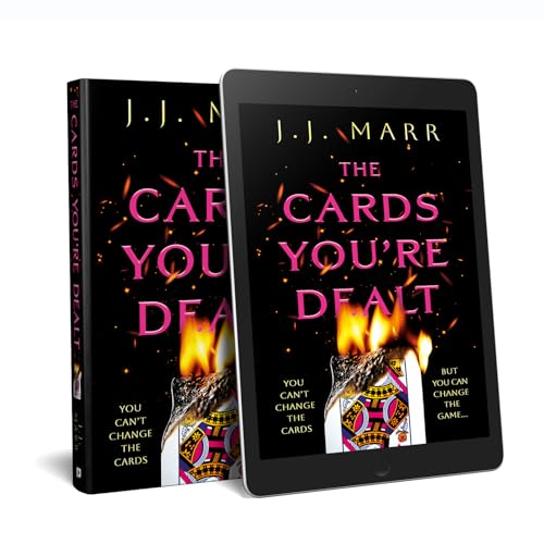 Book cover of "The Cards You’re Dealt" showing burning playing cards.