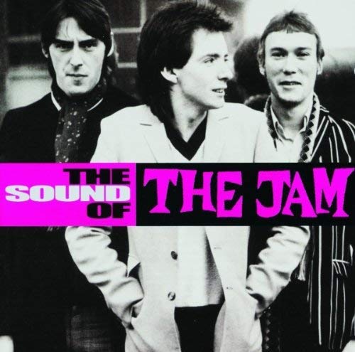Black and white photo of The Jam band members with pink text.