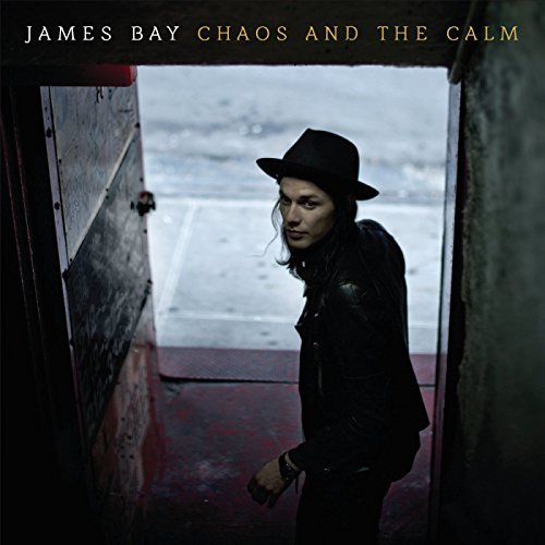 James Bay in a hat, standing in a doorway, album cover.