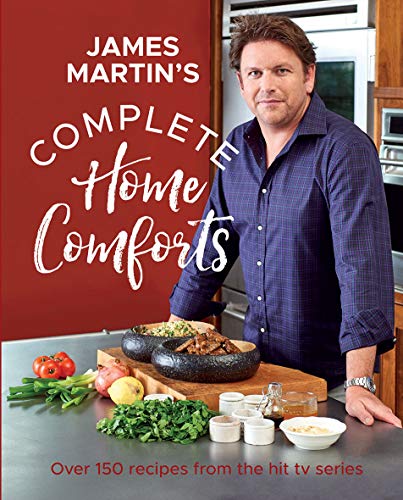 James Martin stands in a kitchen behind a counter with bowls of food.