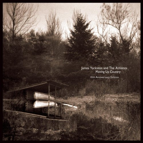 Sepia-toned album cover with a small building and stacked lumber.