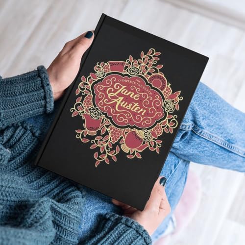 A person in a blue sweater holds a black book titled The Complete Novels of Jane Austen.