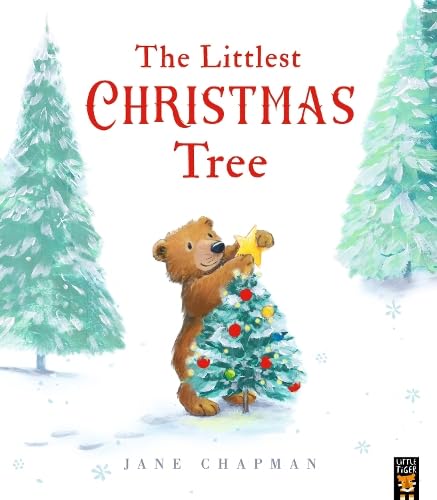 A brown bear places a yellow star on a small decorated Christmas tree.