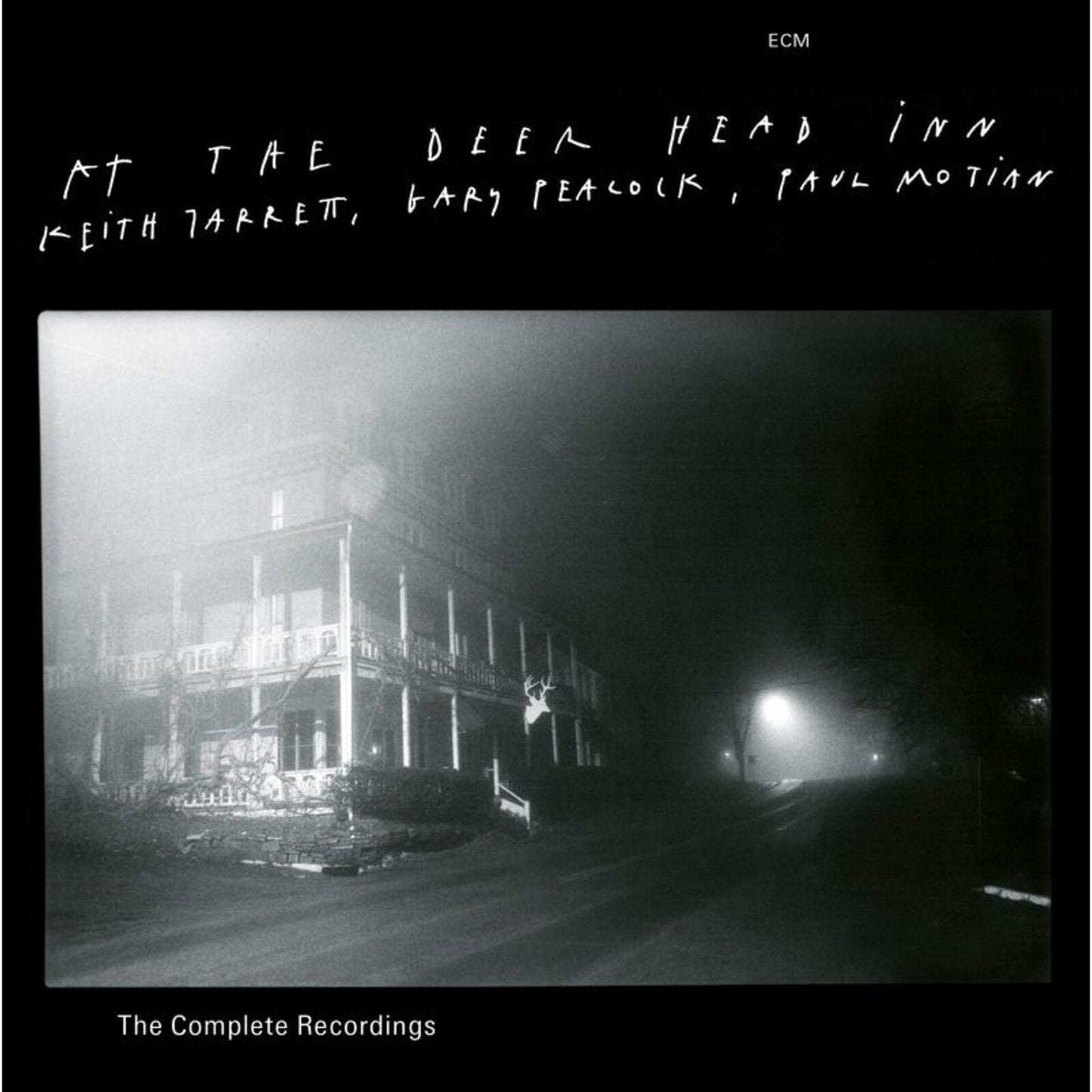 Dark album cover with a shadowy building and deer silhouette.