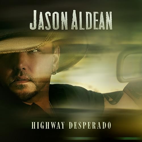 Jason Aldean wearing a cowboy hat in a motion-blurred car interior.
