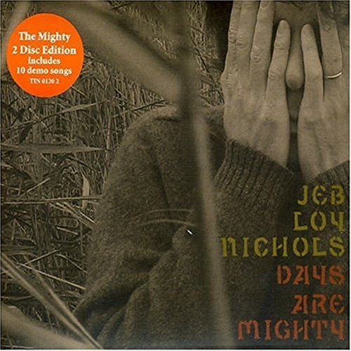 CD cover featuring a person in a sweater with hands covering their face.