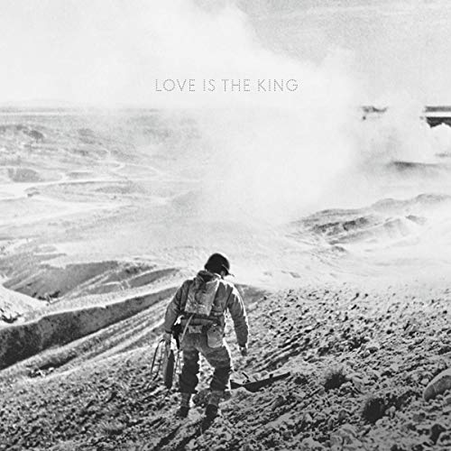 Black and white vinyl album cover with man walking away in a desert landscape.