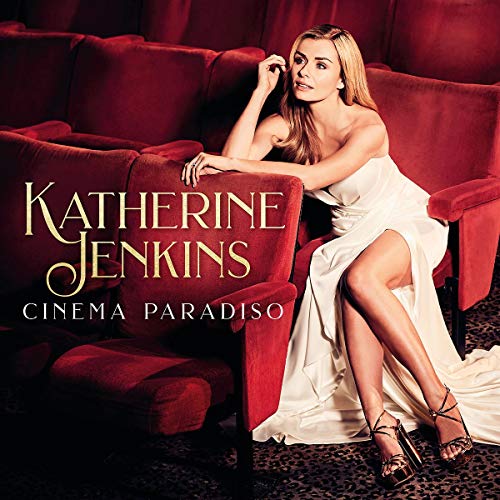 Katherine Jenkins in a white dress seated in a red movie theater.